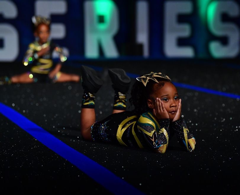 Cheerleaders posing after doing their routine on the mat at competition